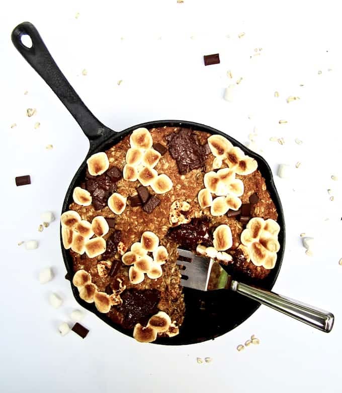 S’mores Oatmeal Cookie Skillet Cake recipe - This vegan and gluten free thick cookie cake is a hybrid between oatmeal bars and cookies, with chocolate chunks, marshmallows, oats, coconut flour and flavorful hints of cinnamon, nutmeg and ginger. A new spin on an old classic, perfect for summer or anytime of year! | veganchickpea.com